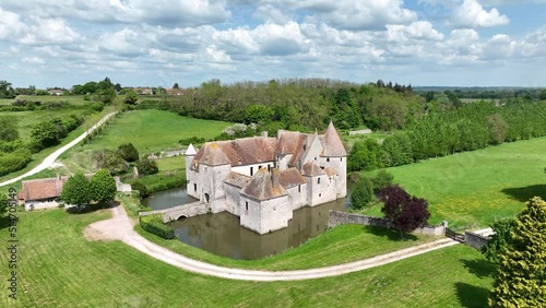 Aerial view of Buranlure water castle in the middle of a lush green meadow in the Loire valley