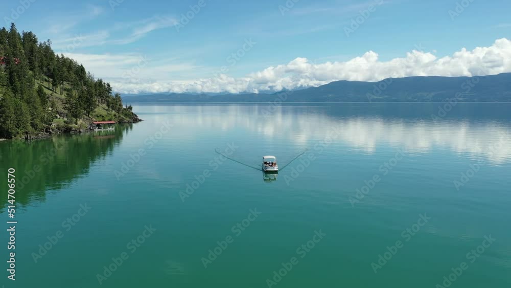 Aerial of family on pontoon boat on Flathead Lake, Montana on clear calm sunny summer morning 4K. Aerial of family on pontoon boat on Flathead Lake, Montana on clear calm sunny summer morning 4K.