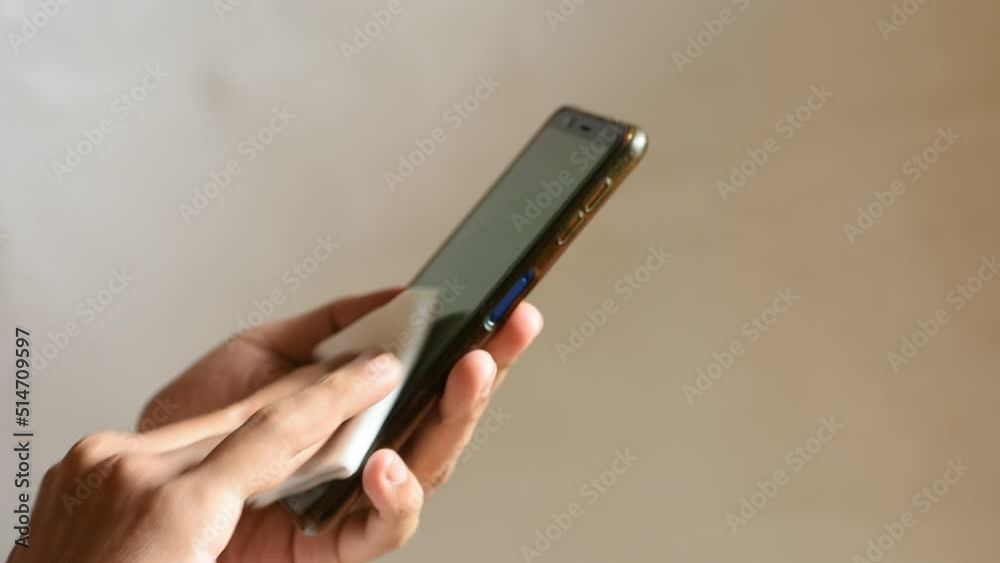 Close up ,man cleaned his cellphone with anti-septic tissue Close up ,man cleaned his cellphone with anti-septic tissue