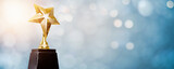 golden trophy award bokeh soft blue background. copy space for text. Winner or 1st place gold trophy award concept