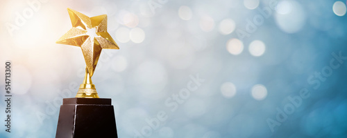 golden trophy award bokeh soft  blue background. copy space for text. Winner or 1st place gold trophy award concept photo