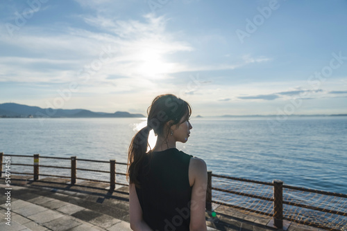 夕暮れの海にいる女性
