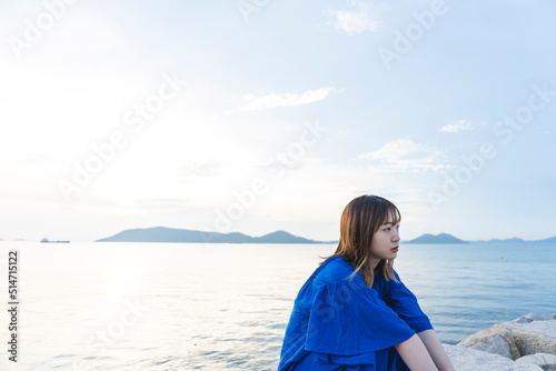 夕暮れの海にいる青いワンピースの女性 © peach100