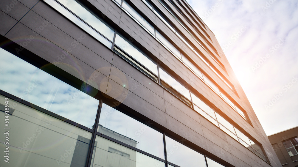 Glass and aluminum facade of a modern office building. View of futuristic architecture. Office building with cloud reflection on windows Glass and aluminum facade of a modern office building. View of futuristic architecture. Office building with cloud reflection on windows