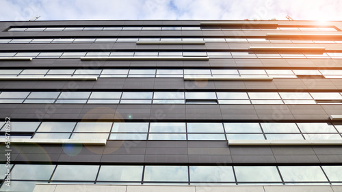 Glass and aluminum facade of a modern office building. View of futuristic architecture. Office building with cloud reflection on windows