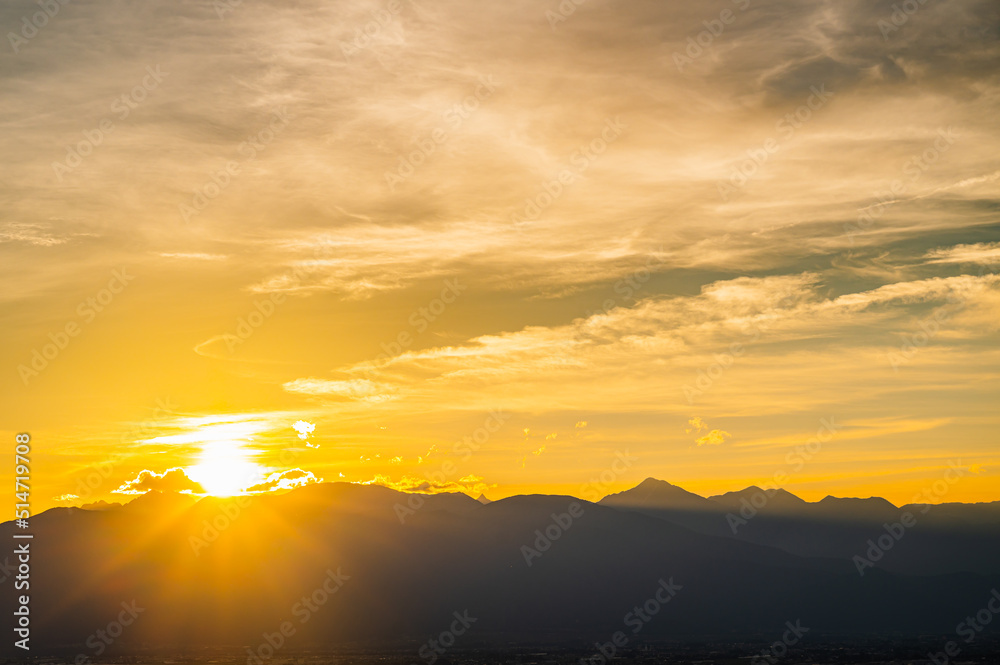 夕日が沈む初夏の山岳風景