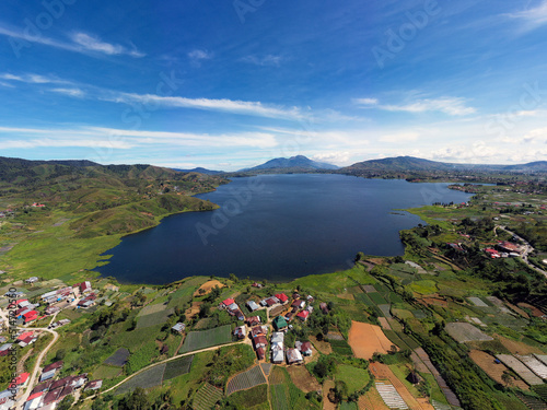 The Kembar lake from west sumatra in sunny day and blue sky reflection sorrounded by green hills and talang volcano background photo