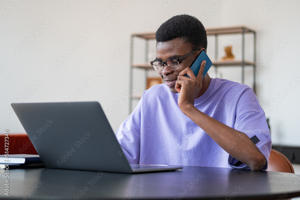 Black businessman talk on the phone, laptop on desk in office room Black businessman talk on the phone, laptop on desk in office room