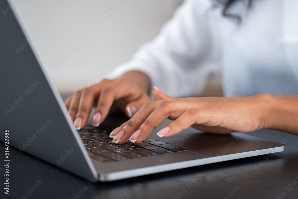 African businesswoman hands typing on the laptop keyboard on desk African businesswoman hands typing on the laptop keyboard on desk