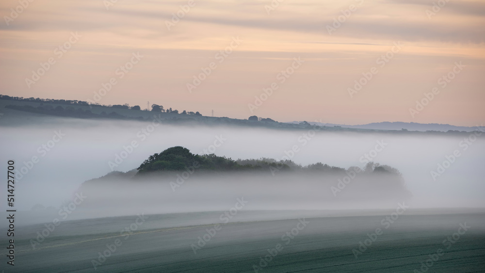 Beautiful vibrant landscape image of sea of fog rolling across South Downs English countryside during Spring sunrise Beautiful vibrant landscape image of sea of fog rolling across South Downs English countryside during Spring sunrise