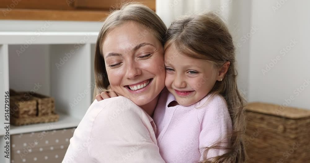 Happy loving mom hugging sweet pretty little daughter girl with care, devotion, gratitude. Kid embracing, tightening mother with cheek touches, smiling. Motherhood, family concept Happy loving mom hugging sweet pretty little daughter girl with care, devotion, gratitude. Kid embracing, tightening mother with cheek touches, smiling. Motherhood, family concept
