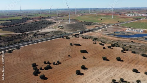 Large wind turbines with blades in field aerial view bright orange sunset blue sky wind park drone turn.  Alternative energy (ID: 514729162)