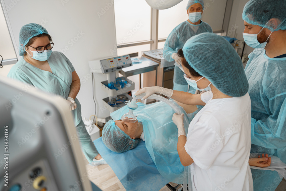 Well-trained anesthesiologist follows the patient during the surgery in clinic Well-trained anesthesiologist follows the patient during the surgery in clinic
