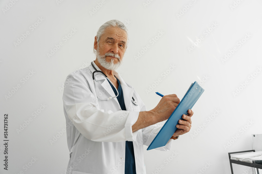 Professional doctor taking notes on clipboard and looking camera in medicine center Professional doctor taking notes on clipboard and looking camera in medicine center