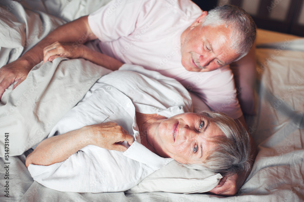 Happy elderly couple wakes up in bed in the morning Happy elderly couple wakes up in bed in the morning