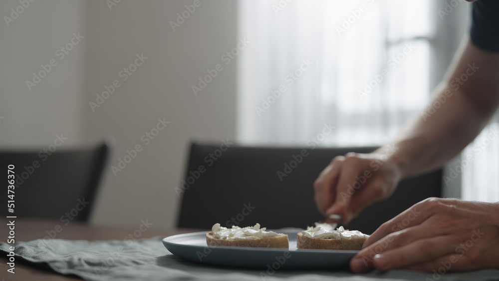 Man making bruschettas with cream cheese and smoked salmon Man making bruschettas with cream cheese and smoked salmon