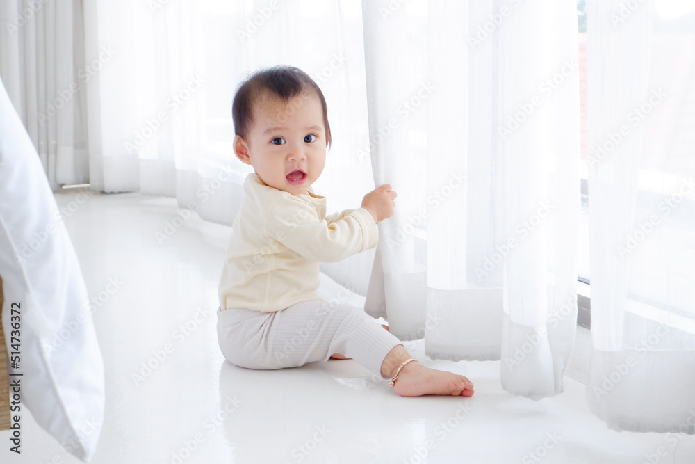 A cute little boy sat by the white curtain. A cute little boy sat by the white curtain.