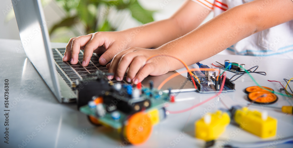 Asian kid boy learns coding and programming with laptop for Arduino robot car, Little child students typing code in computer online with car toy, STEAM education AI technology future course learning