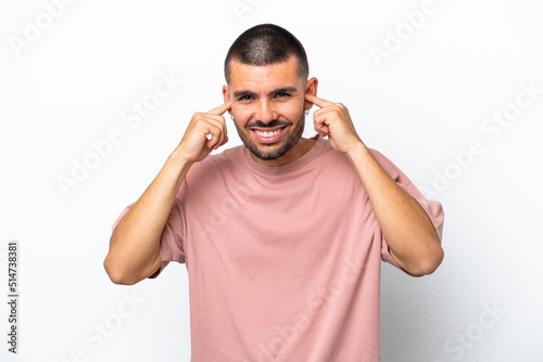 Young caucasian man isolated on white background frustrated and covering ears