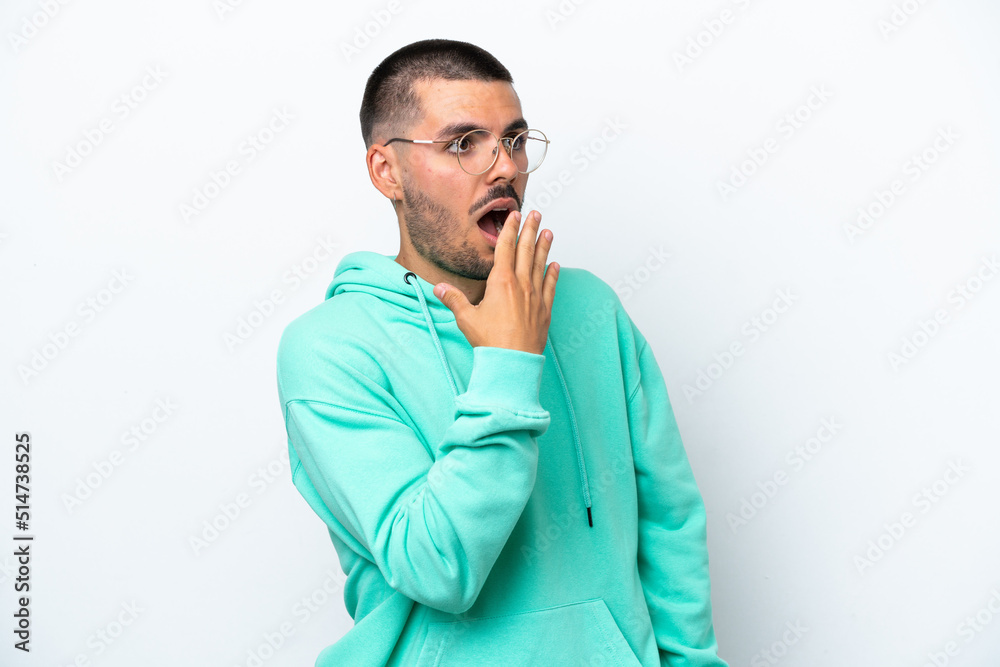 Young caucasian man isolated on white background yawning and covering wide open mouth with hand Young caucasian man isolated on white background yawning and covering wide open mouth with hand