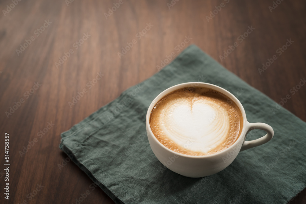 Obraz premium Fresh flat white with latte art in ceramic cup on wood table