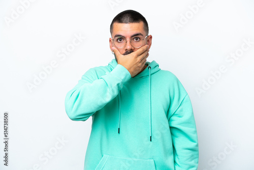 Young caucasian man isolated on white background covering mouth with hand © luismolinero