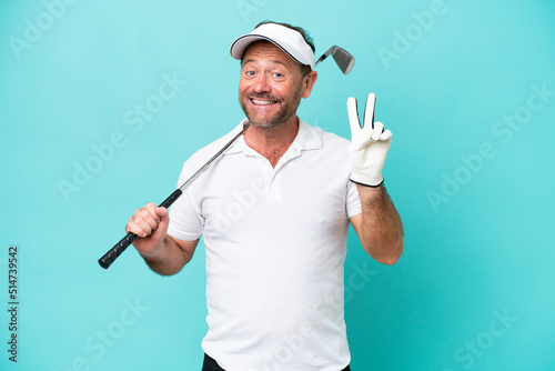 Middle age caucasian golfer player man isolated on blue background smiling and showing victory sign