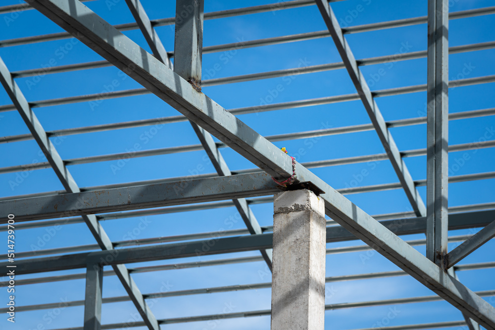 Iron beam roof structure of the house building, on blue sky background. Construction industrial working site and object photo.. Iron beam roof structure of the house building, on blue sky background. Construction industrial working site and object photo..