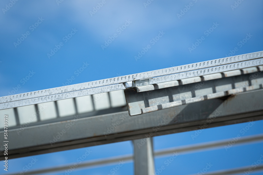Iron beam roof structure of the house building, on blue sky background. Construction industrial working site and object photo.. 
