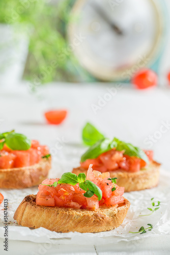 Crisp and healthy bruschetta with tomato and herbs as snack.