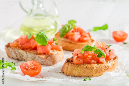 Tasty and fresh bruschetta with basil and tomatoes for breakfast.