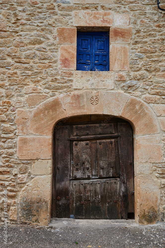 Stone facade with ancient wooden door in Pesquera de Ebro Stone facade with ancient wooden door in Pesquera de Ebro