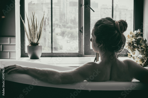 woman lies in a bath with foam