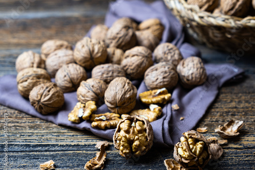 Whole and cracked walnuts on wooden rustic background, fresh walnut concept, healthy nuts.