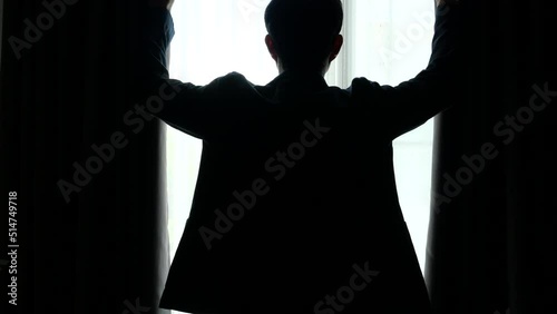 Silhouette man closing the curtain