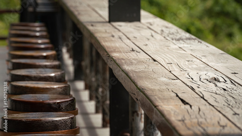 Row of vintage style wooden table bar and round seat without people. Interior decoration and object photo. Selective focus.