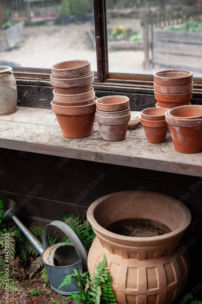 Terracotta pots and watering can in the gardener hut Terracotta pots and watering can in the gardener hut