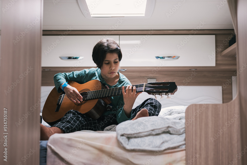 Girl playing the guitar in the caravan, family route
