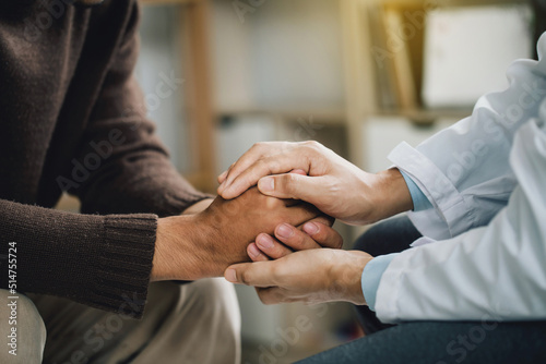 Close-up of psychiatrist hands together holding palm of her patient. comforts an anxious depression patient for medical treatment in diagnostic room  PTSD Mental health concept