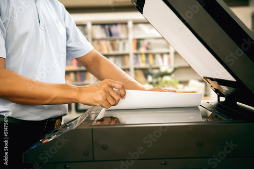 Photocopier printer, Close up hand office man place the sheet on panel to using the copier or photocopy machine for scanning document or printing paper or Xerox a sheet.