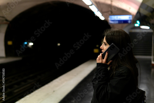 Canvas Print Young woman talking on the phone in the paris subway
