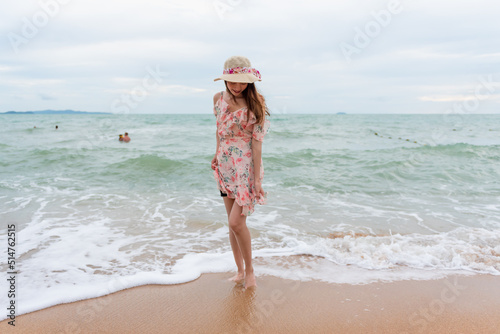 Young woman barefoot walking on the sand beach.
