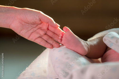 hand touching newborn baby foot with love