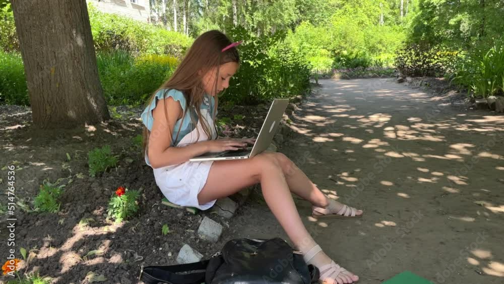girl relaxing outdoors in park with laptop, chatting with friends online, streaming, blogging. modern youth, teenager. Bloggers study online in nature, it's time to go to school, new school year girl relaxing outdoors in park with laptop, chatting with friends online, streaming, blogging. modern youth, teenager. Bloggers study online in nature, it's time to go to school, new school year