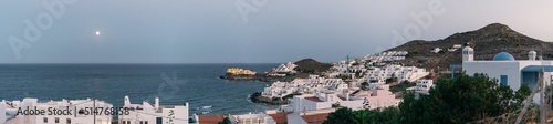 Fototapeta Naklejka Na Ścianę i Meble -  Panoramic view of a coastal town of white houses on the Mediterranean coast with a full moon over the sea after sunset