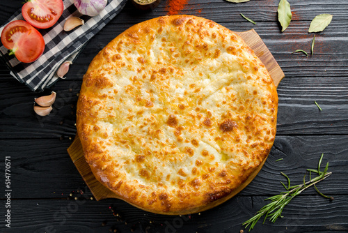 khachapuri with cheese, megrelian khachapuri, georgian cuisine on black wooden table top view photo