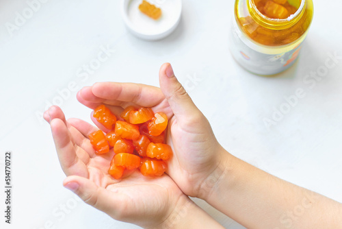 child holds a handful of vitamins for children in the palms. vitamin overdose, synthetic vitamins photo