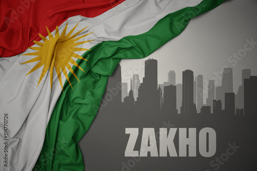 abstract silhouette of the city with text Zakho near waving national flag of kurdistan on a gray background.3D illustration photo