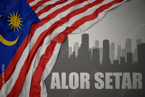 Фотография abstract silhouette of the city with text Alor Setar near waving national flag of malaysia on a gray background