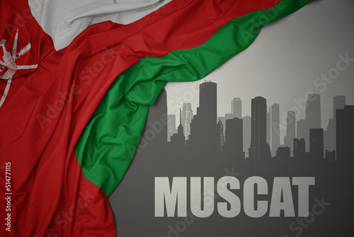 abstract silhouette of the city with text Muscat near waving national flag of oman on a gray background.3D illustration